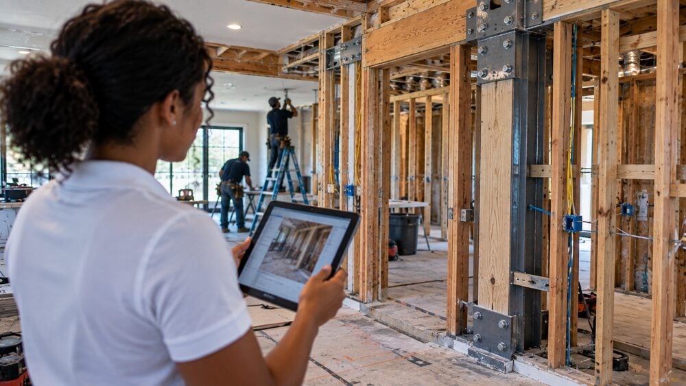 Precision Estimates specialist documenting code-required structural framing and bracing on a reconstruction site